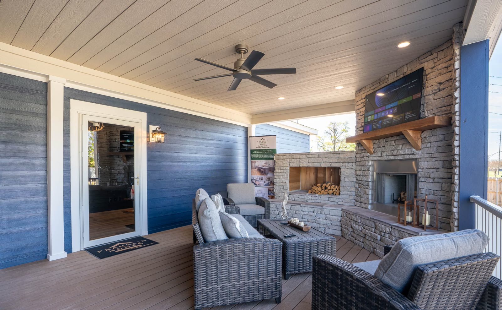 Covered porch with a stacked-stone fireplace on The Tollison Creek